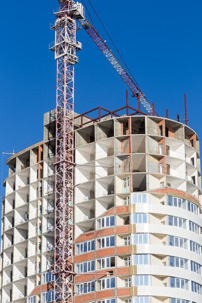 Crane and building construction site against blue sky. Buildings