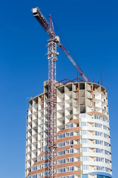 Kraan en gebouw bouwplaats tegen blauwe hemel. Gebouwen — Stockfoto