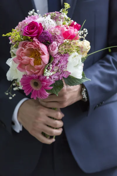 Well-dressed man holding a bouquet of flowers. Holidays and cele — Stock Photo, Image