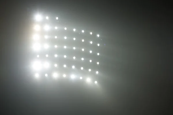 Brillantes luces blancas y amarillas del estadio con niebla — Foto de Stock