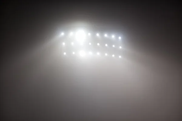 Zářivě bílé a žluté stadionu světla s mlha — Stock fotografie