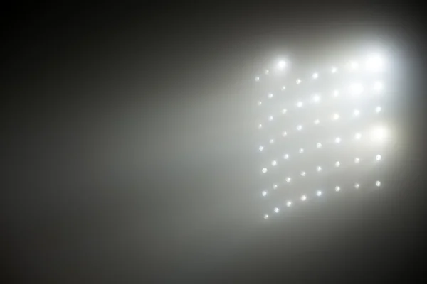 Luzes brancas e amarelas brilhantes do estádio com nevoeiro — Fotografia de Stock