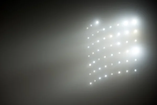Luzes brancas e amarelas brilhantes do estádio com nevoeiro — Fotografia de Stock