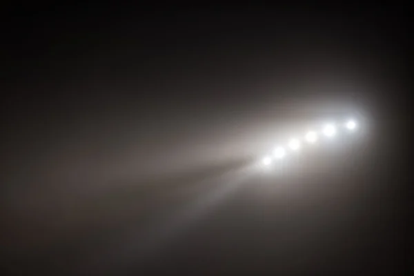 Brillantes luces blancas y amarillas del estadio con niebla —  Fotos de Stock