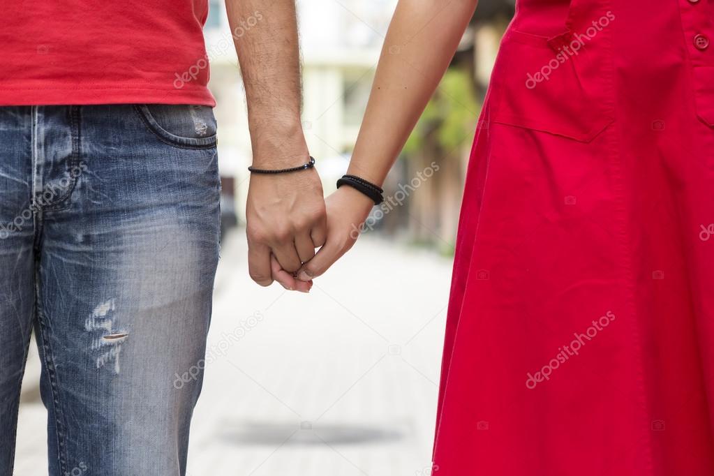 Young couple holding hands on the street together