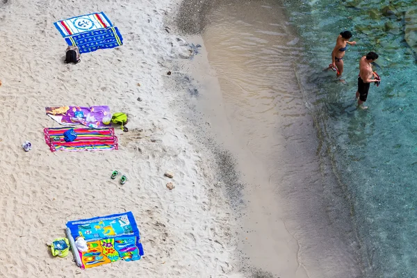 Bovenaanzicht van handdoeken op Tsigrado Beach op het eiland Milos, Cycladen, — Stockfoto