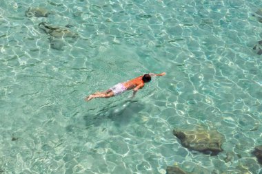 Top view of a boy swimming at Milos, in Greece clipart