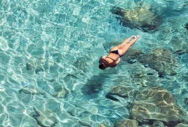 Top view of woman swimming at Milos, in Greece clipart