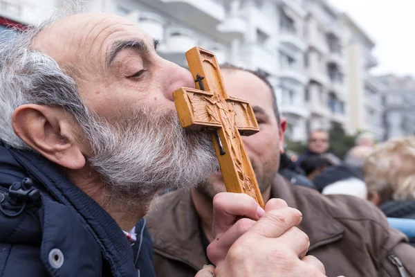 Un hombre besa una cruz de madera recuperada del mar durante el bl — Foto de Stock