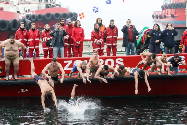 As pessoas mergulham para recuperar uma cruz de madeira jogada no mar, du — Fotografia de Stock