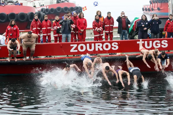 As pessoas mergulham para recuperar uma cruz de madeira jogada no mar, du — Fotografia de Stock