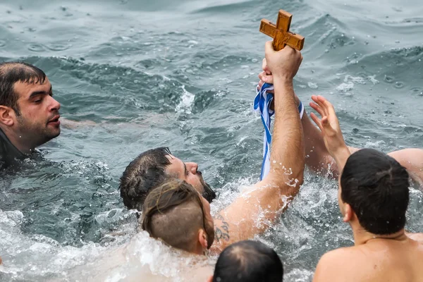 Un nageur embrasse une croix de bois récupérée de la mer, pendant — Photo