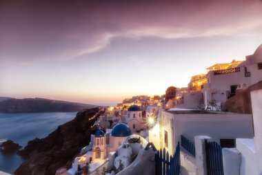 Oia geleneksel beyaz evlerin Oia Santori batımında görünümünü