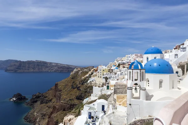Blauwe koepelvormige kerken op de Caldera in Oia op het Griekse eiland — Stockfoto
