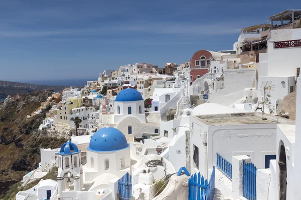 Kyrkor med blåa kupoler på Caldera på Oia på den grekiska ön — Stockfoto