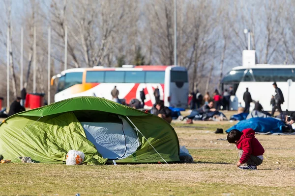 Tusentals migranter och flyktingar väntar i parkeringsplats o — Stockfoto