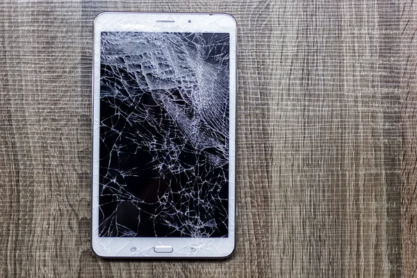 Broken glass of tablet on the grunge wood. Selective focus. Low — Stock Photo, Image