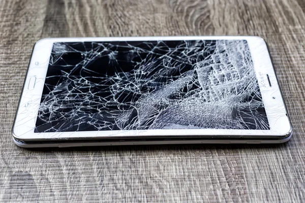 Broken glass of tablet on the grunge wood. Selective focus. Low — Stock Photo, Image