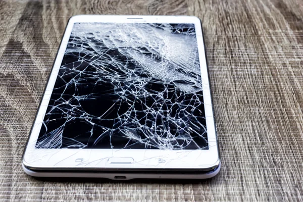 Broken glass of tablet on the grunge wood. Selective focus. Low — Stock Photo, Image