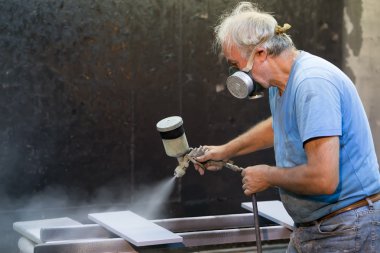 Ahşap tahta boyama boya tabancası ile protecti giyen adam işçi