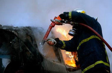 İtfaiyeci yanan bir araba bir patlamadan sonra mücadele