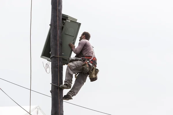 Lucrător alpinism pe linia de transmisie a polilor de beton electric la — Fotografie, imagine de stoc