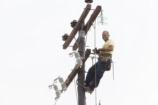 Escalada del trabajador en línea de transmisión de poste de concreto eléctrico a — Foto de Stock