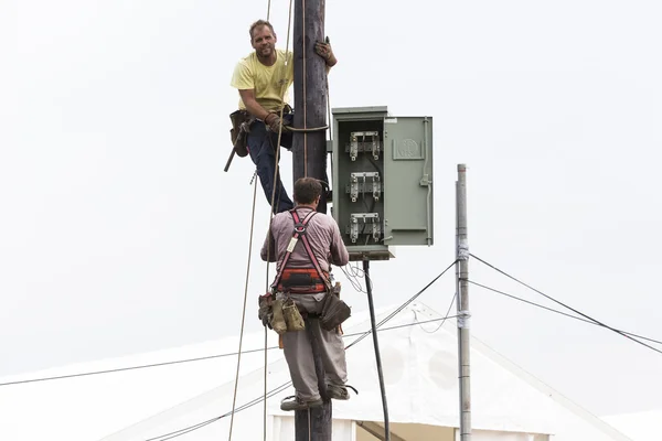 Ouvriers grimpant sur la ligne de transport de poteaux en béton électrique t — Photo