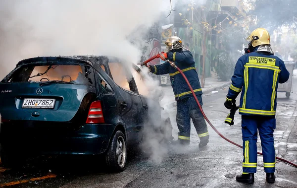 Bomberos luchando contra un coche en llamas después de una explosión — Foto de Stock