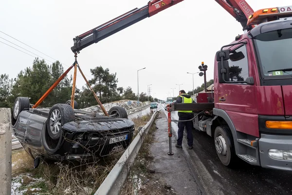 Muž, závěsné poškozené auto nad odtahový vůz cestě — Stock fotografie