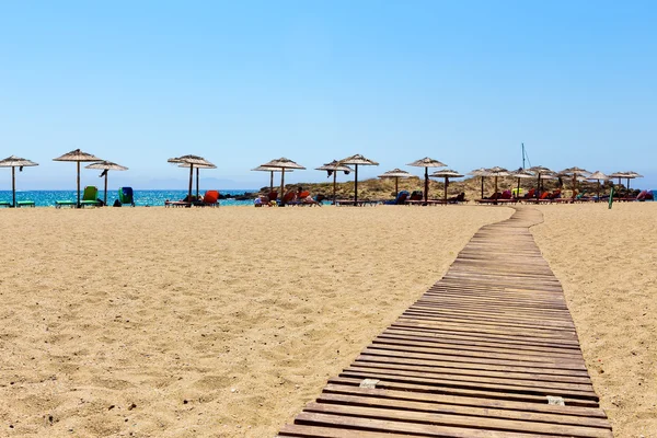 Stranden paraplyer korridor till havet semester — Stockfoto