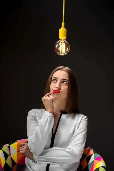 Mujer pensando con lámpara por encima de la cabeza — Foto de Stock