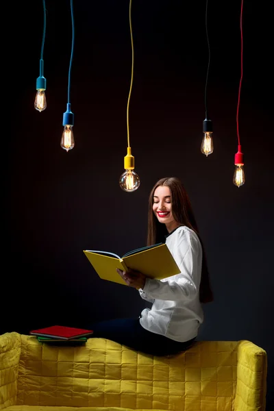 Mladý kreativní student barevné lampy a knihy — Stock fotografie