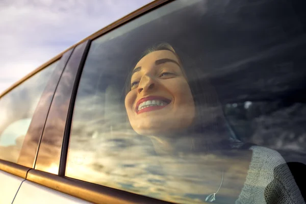 Mujer disfrutando del paisaje nublado mirando por la ventana del coche — Foto de Stock