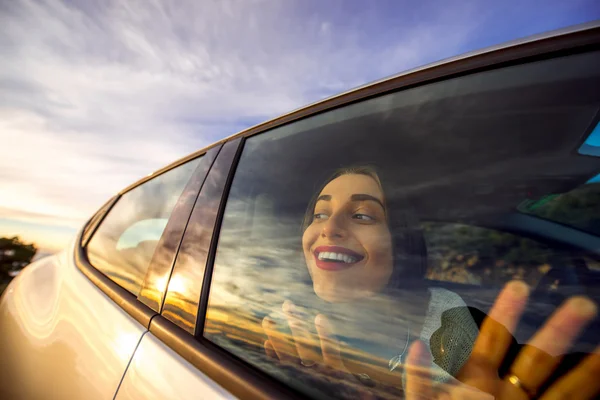 Mujer disfrutando del paisaje nublado mirando por la ventana del coche — Foto de Stock