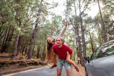 Couple having piggyback ride in the forest