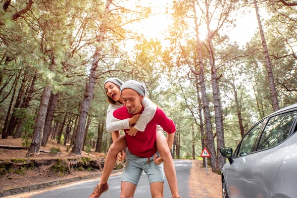 Couple having piggyback ride in the forest — Stockfoto