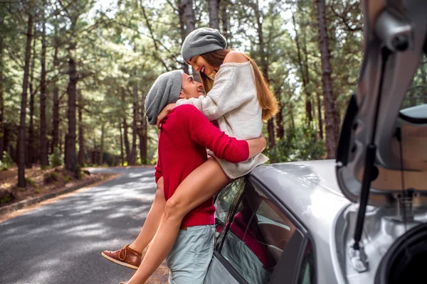 Young couple traveling by car in the forest — Zdjęcie stockowe