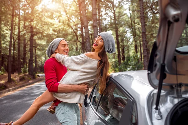 Young couple traveling by car in the forest — Stockfoto