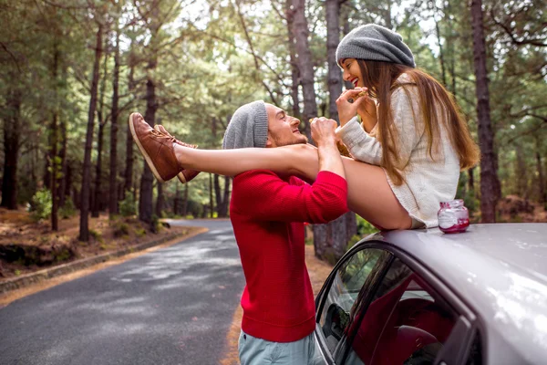 Coppia giovane che viaggia in auto nella foresta — Foto Stock