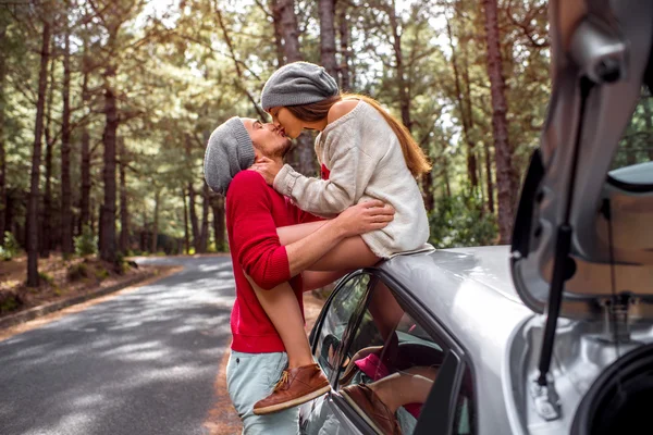 Young couple traveling by car in the forest — 图库照片