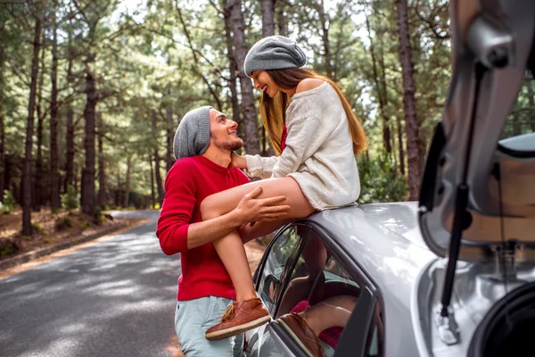 Young couple traveling by car in the forest — Stock fotografie