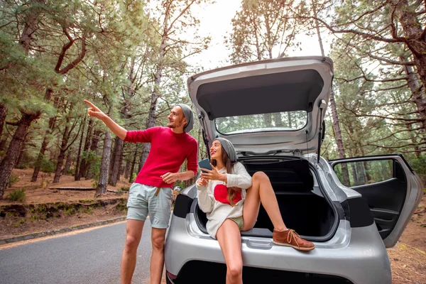 Ehepaar mit Auto im Wald unterwegs — Stockfoto