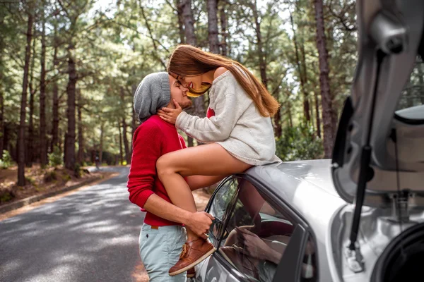 Young couple traveling by car in the forest — 스톡 사진