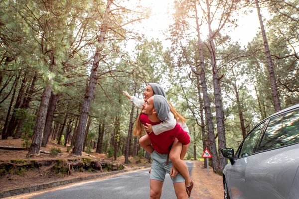 Couple having piggyback ride in the forest — 图库照片