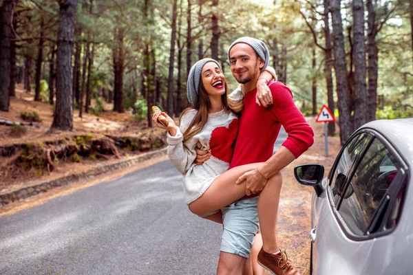 Young couple traveling by car in the forest — Stockfoto