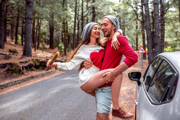 Coppia giovane che viaggia in auto nella foresta — Foto Stock