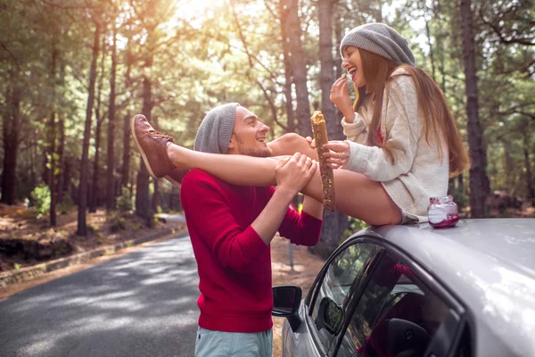 Young couple traveling by car in the forest — Stockfoto