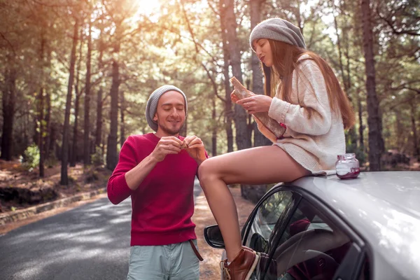 Young couple traveling by car in the forest — 스톡 사진