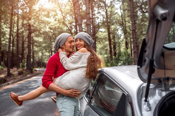 Young couple traveling by car in the forest